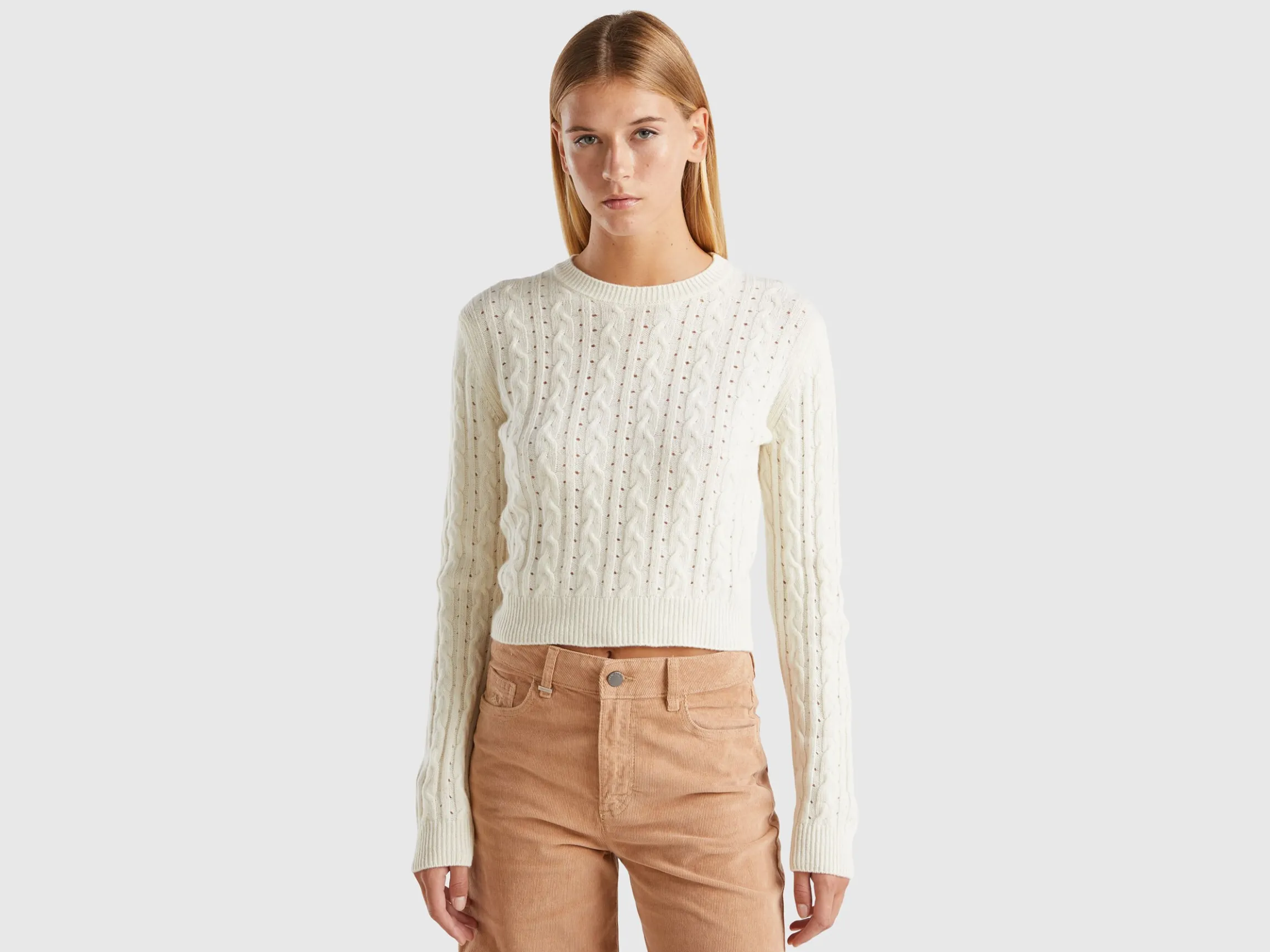 Cropped sweater with cable knit and perforations