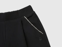 Trousers with jewel-like applique